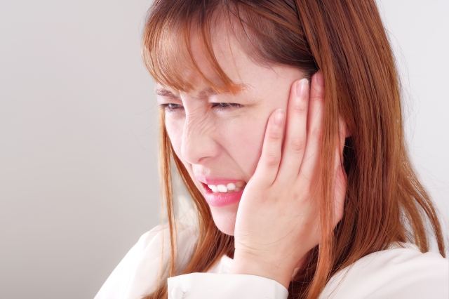 噛みしめによる痛みに悩む女性
